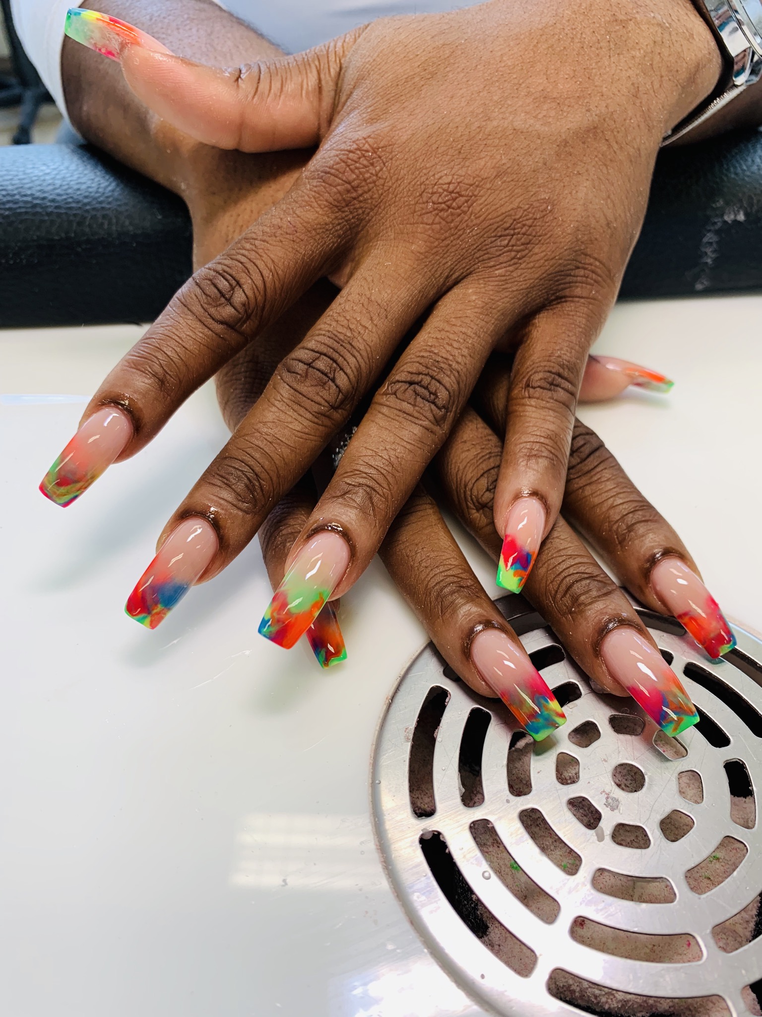 Handen met kleurrijke tips op lange nagels, op de manicuretafel