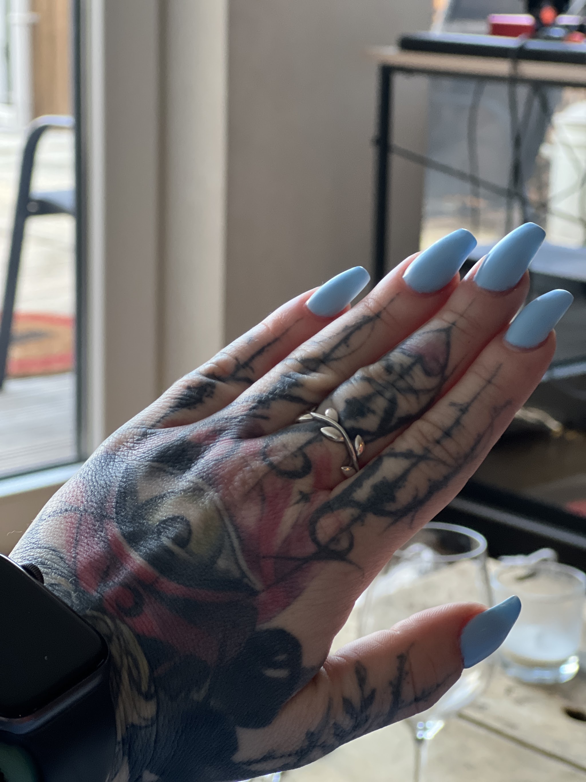 Hand met matblauwe lange nagels
